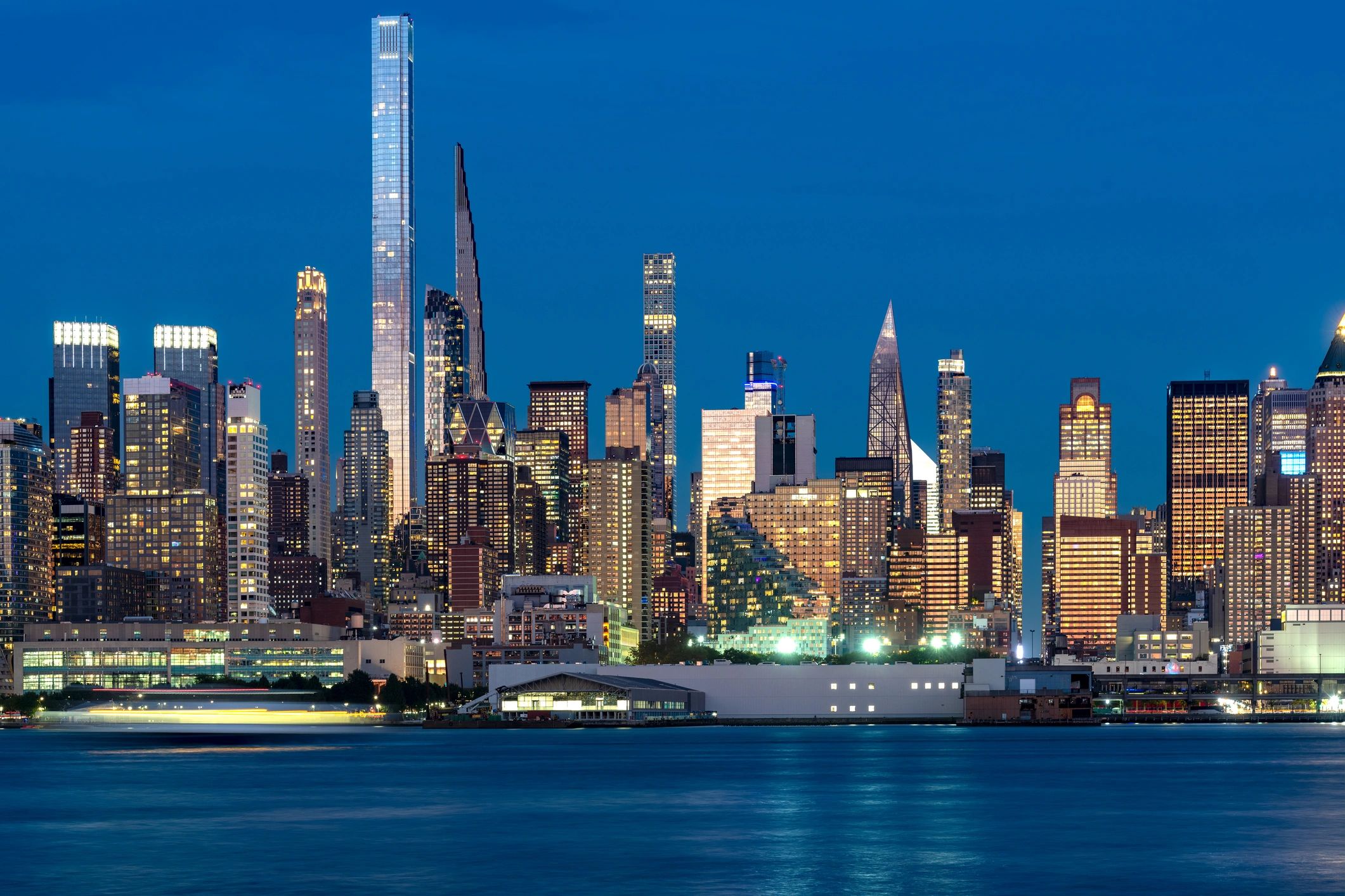 The impressive Midtown Manhattan skyline featuring the ultra thin skyscrapers of Billionaires Row illuminated at night in USA