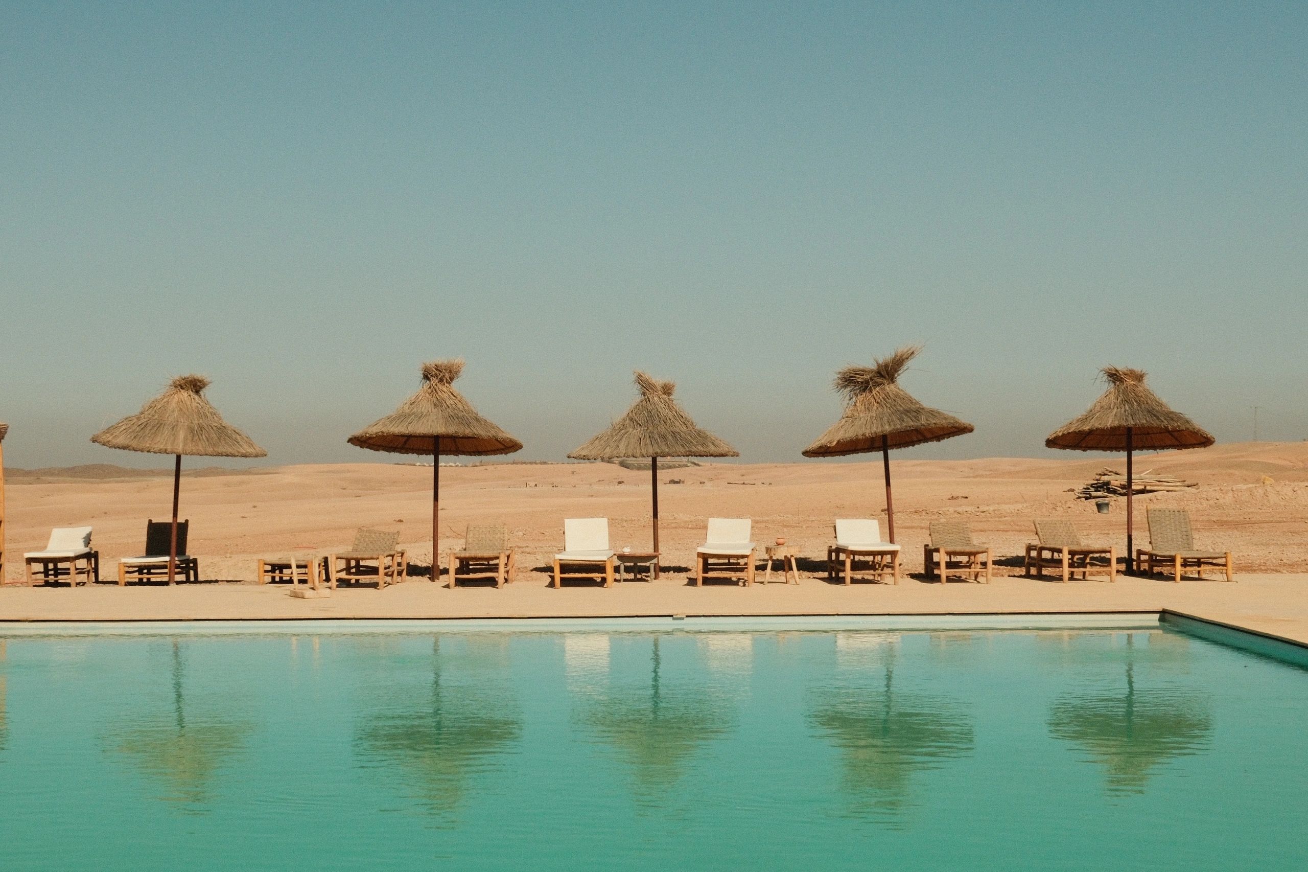 Luxury resort pool with loungers and umbrellas