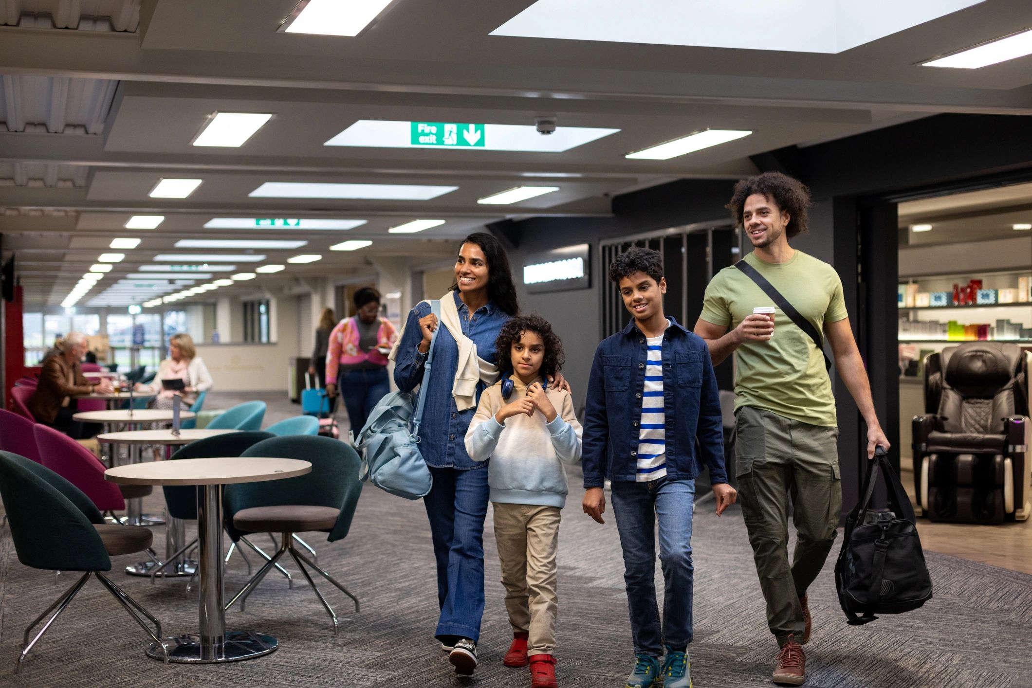Family walking through an airport terminal with luggage before departure