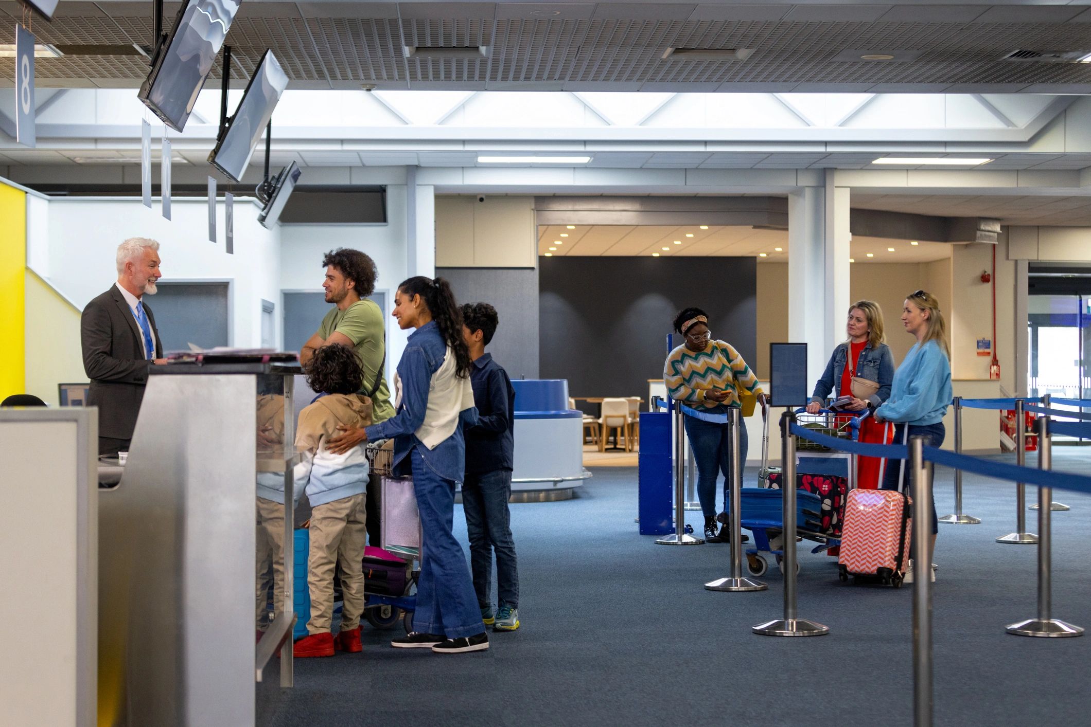 Family checking in at an airport desk before a well-planned holiday