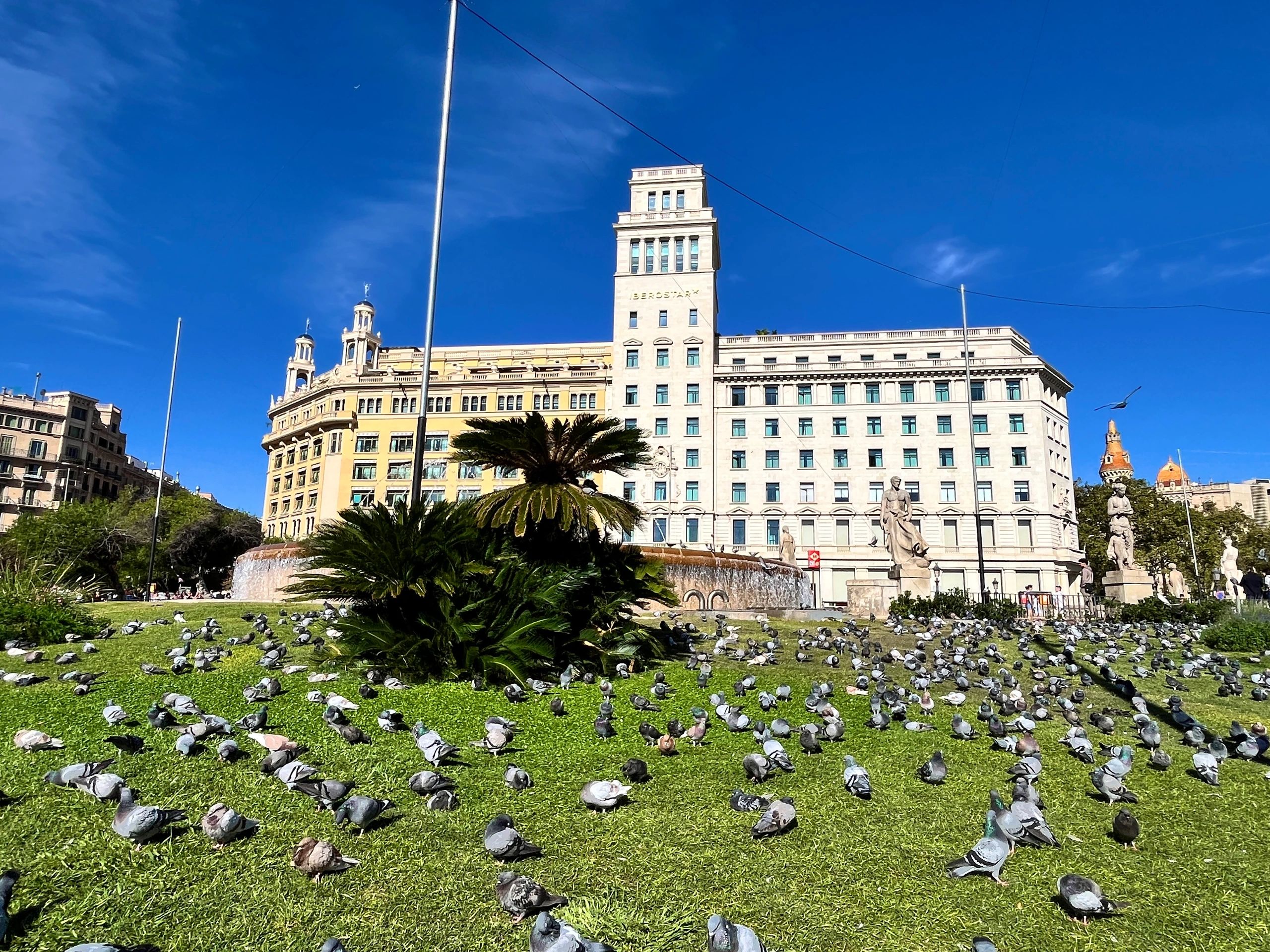 Barcelona city square and fountain under a bright blue sky