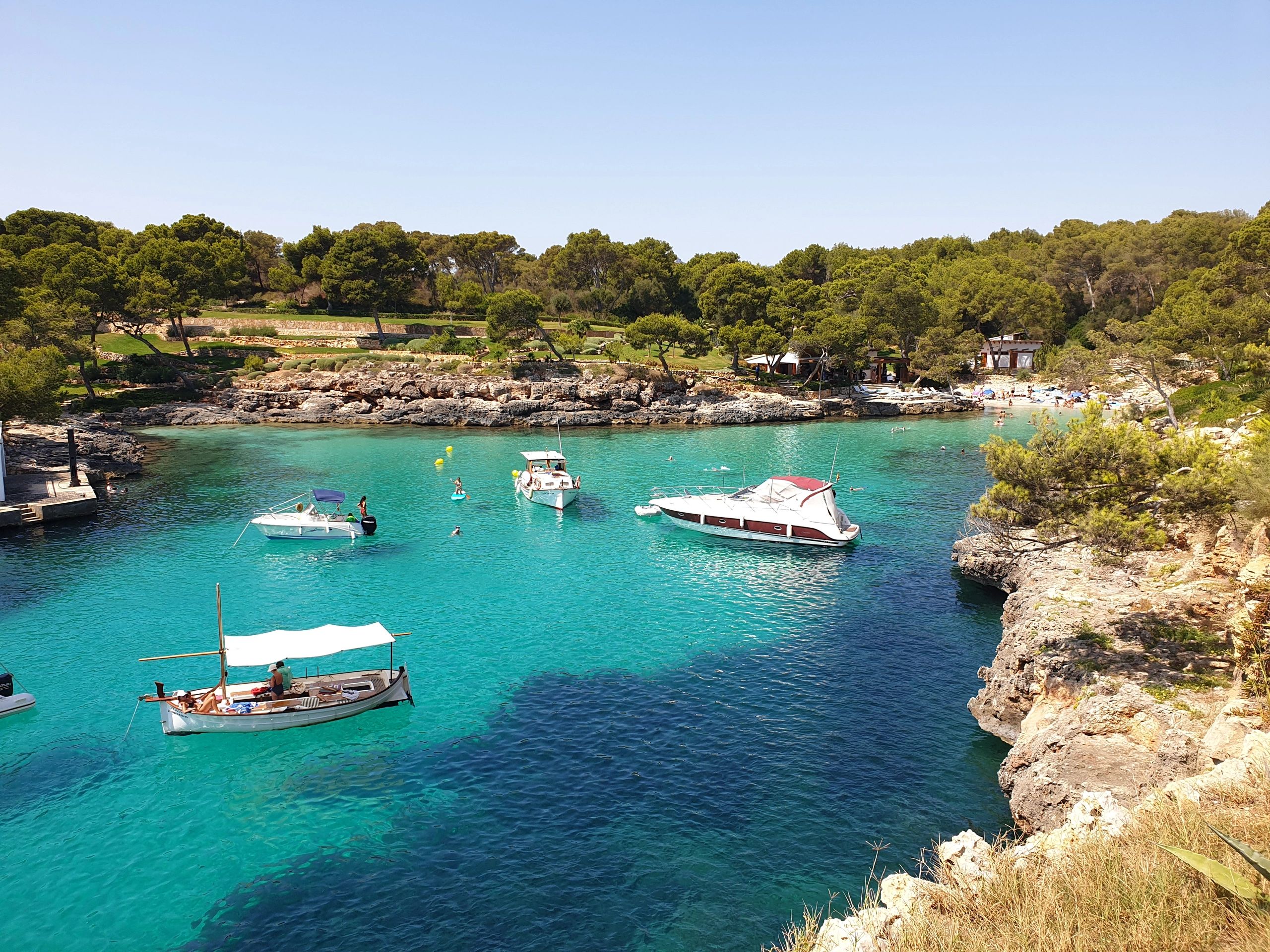 Rocky Majorca coastline with turquoise sea and anchored boats