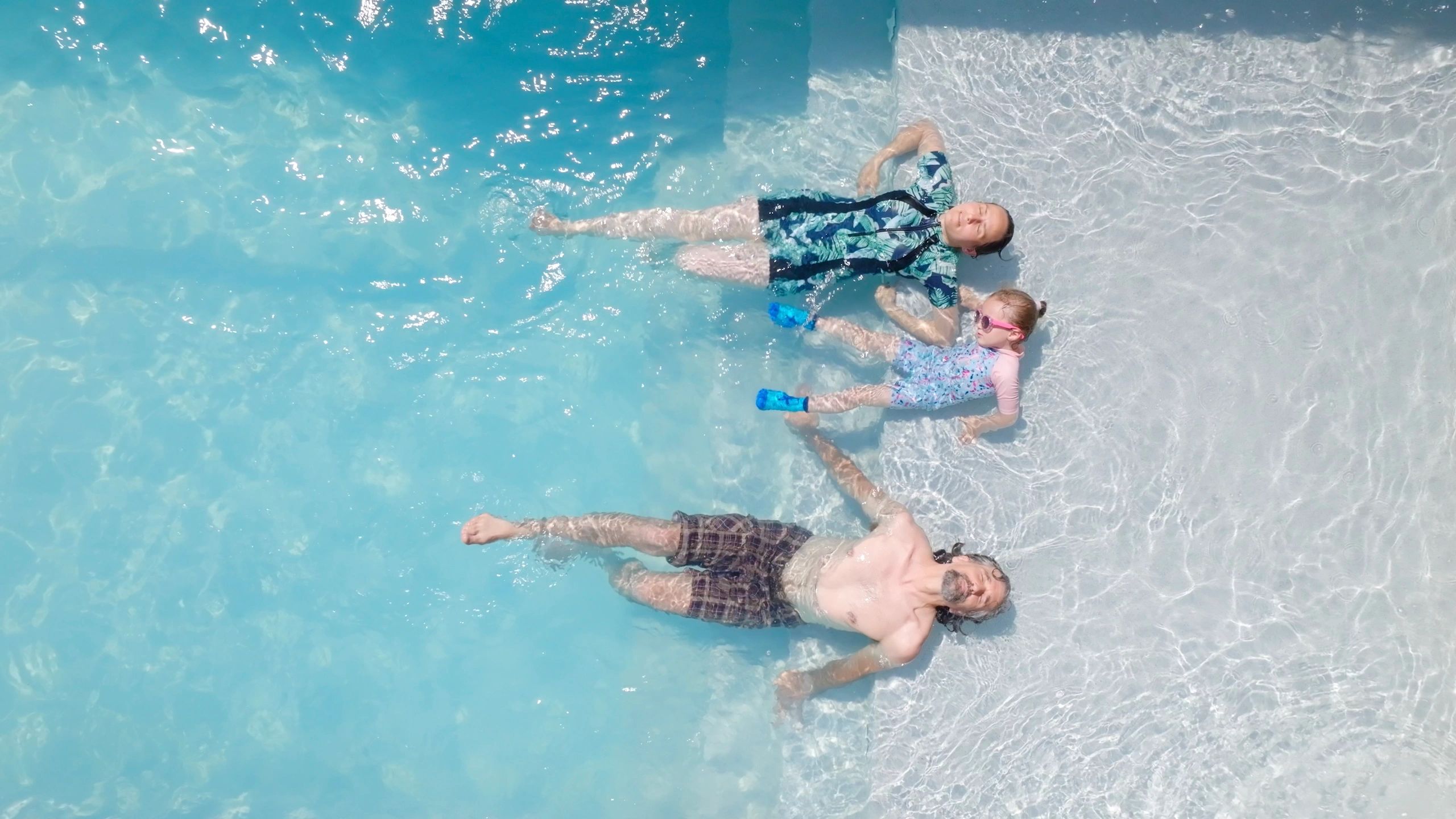 Family enjoying a sunny beach resort holiday with pool and sea views